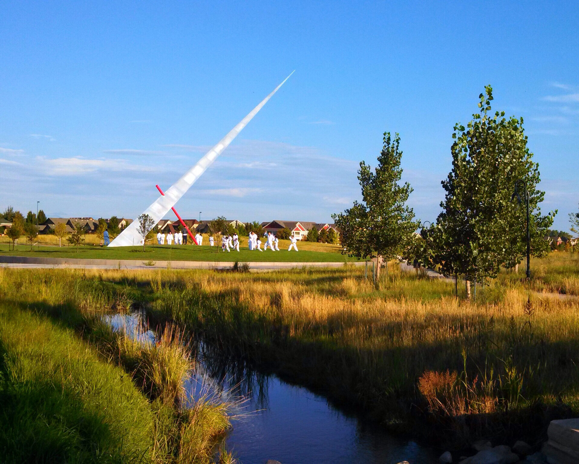 White sculpture in park with river